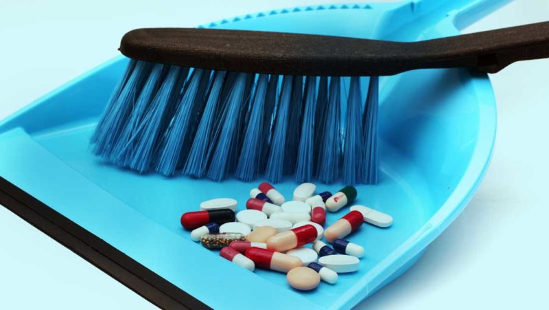 Dustpan & brush sweeping up pills