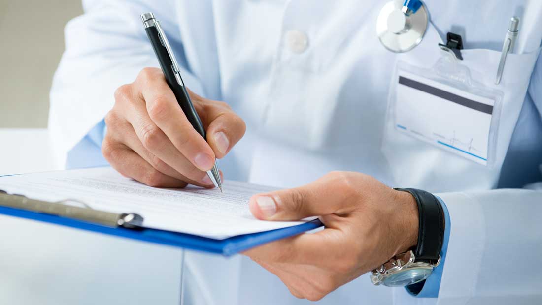 Doctor writing notes on a clipboard