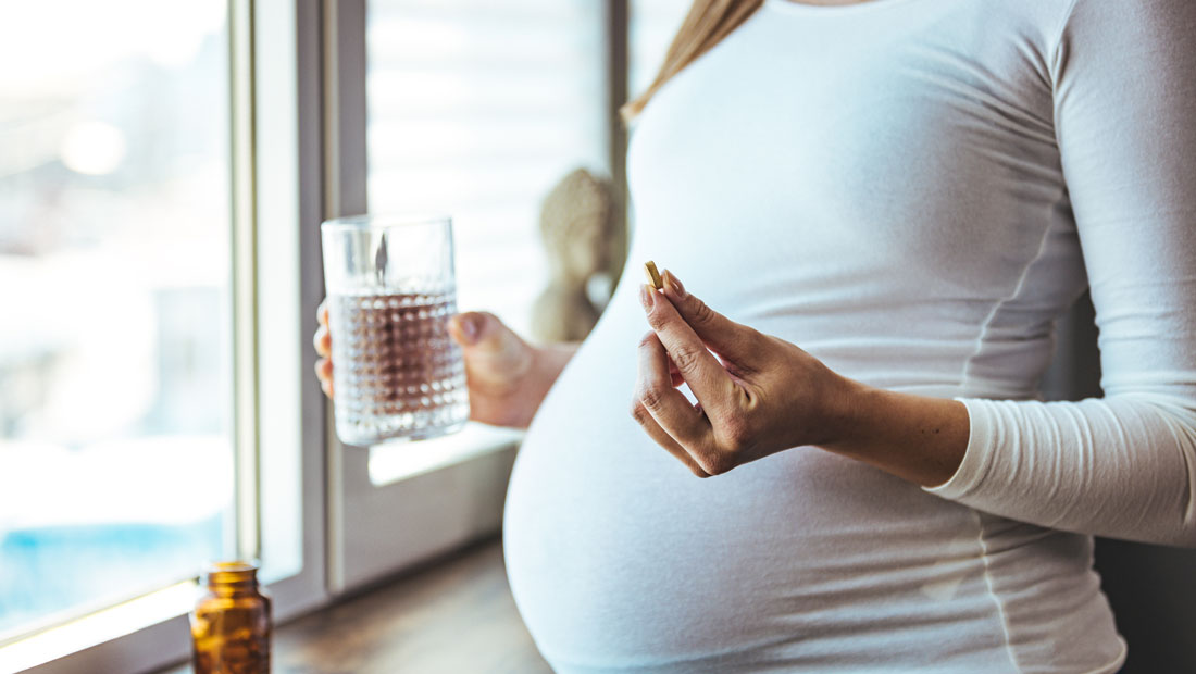 Pregnant woman taking a pill